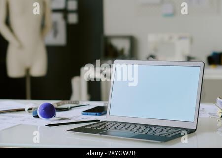 Ordinateur portable argenté sur table en bois blanc dans un atelier moderne Banque D'Images