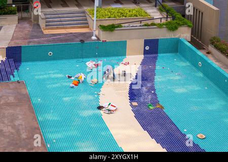 Réparation de piscine. Les ouvriers posent de nouvelles tuiles sur le fond de la piscine, Thaïlande, Pattaya-01.29.2024 Banque D'Images