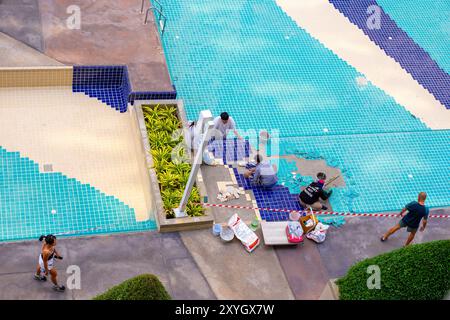 Réparation de piscine. Les ouvriers posent de nouvelles tuiles sur le fond de la piscine, Thaïlande, Pattaya-01.29.2024 Banque D'Images