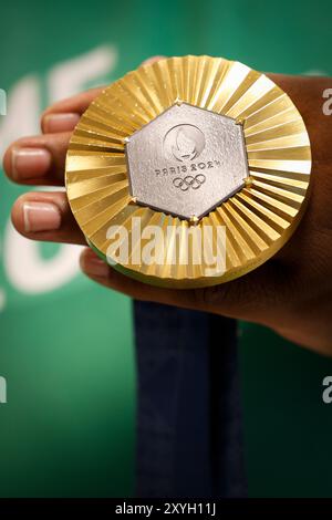 Médaille d'or des Jeux Olympiques de Paris 2024 prise de vue détaillée à la main, vainqueur d'une compétition sportive, symbole de réussite. Jeux olympiques d'été 2024 Banque D'Images