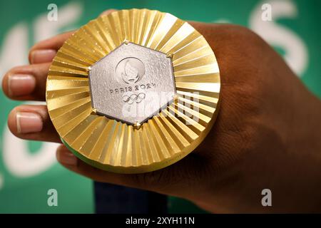 Médaille d'or des Jeux Olympiques de Paris 2024 prise de vue détaillée à la main, vainqueur d'une compétition sportive, symbole de réussite. Jeux olympiques d'été 2024 Banque D'Images