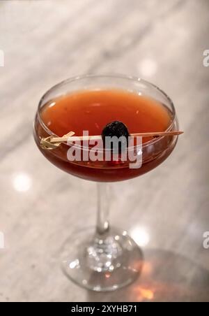 Manhattan cocktail avec une cerise sur un cure-dent vu d'en haut. Pris dans un bar-restaurant. Banque D'Images