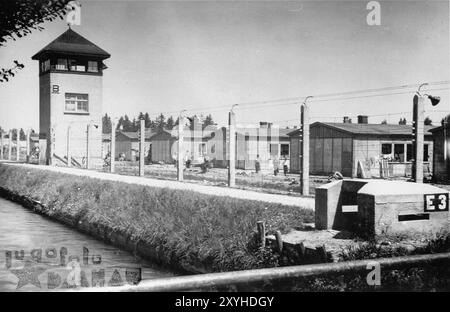 Une vue de la clôture électrique, des douves et des tours de guet de Dachau. Dachau a été le premier camp de concentration nazi, ouvert le 22 mars 1933 (seulement 7 semaines après l'arrivée d'Hitler au pouvoir). Bien qu'il s'agisse d'un camp de travaux forcés et qu'il n'y ait pas de chambres à gaz, la brutalité et les châtiments violents sont la norme. Il y a eu 32000 décès documentés là-bas et plusieurs milliers d'autres non documentés. Le camp principal (Dachau comptait 100 sous-camps) a été libéré par l'armée américaine le 29 avril 1945. Banque D'Images