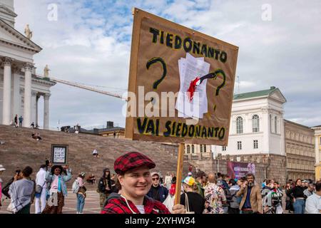 Tiedonanto vai siedonanto ? Manifestant tenant une pancarte en carton lors de la manifestation de Loppu äärioikeiston väkivallalle sur la place du Sénat à Helsinki, en Finlande. Banque D'Images