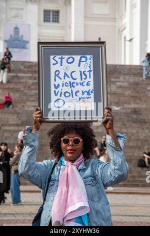 Arrêtez la violence raciste maintenant. Manifestant tenant une pancarte lors de la manifestation de Loppu äärioikeiston väkivallalle sur la place du Sénat à Helsinki, en Finlande. Banque D'Images