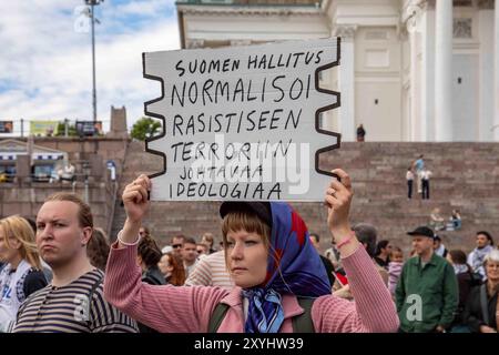 Suomen hallitus normalisoi rasistiseen terroriin johtavaa ideologiaa. Manifestant tenant une pancarte lors de la manifestation de Loppu äärikoikeiston väkivallalle. Banque D'Images