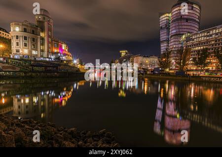 Lumières reflétées dans le canal du Danube, à gauche l'observatoire d'Urania, à droite les tours de bureaux illuminées, plan de nuit, Vienne, Autriche, Europe Banque D'Images