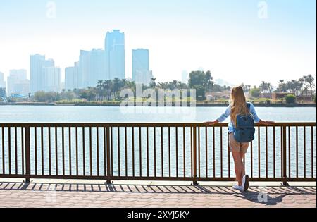 Touriste avec sac à dos et panorama de Sharjah et lac artificiel, Sharjah, Émirats arabes unis Banque D'Images