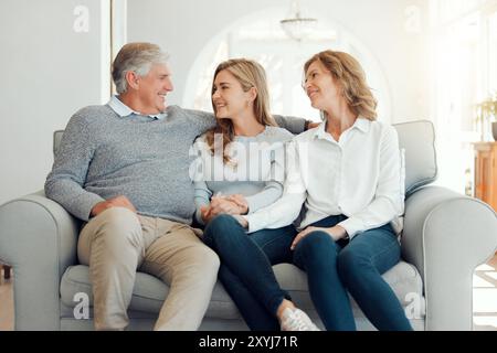 Parents matures, fille et heureux sur le canapé à la maison pour les soins, les liens et le soutien en Angleterre. Les gens, la famille et sourire ou rire sur le canapé dans le salon Banque D'Images
