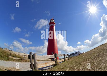 Soleil et tour de phare rouge sur la côte, Schiermonnikoog, pays-Bas Banque D'Images