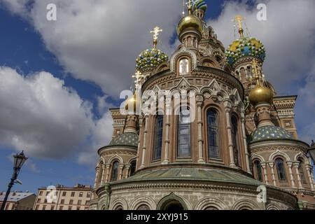 Église russe avec de magnifiques dômes d'oignon et des façades richement décorées dans la lumière du soleil contre un ciel blanc-bleu Banque D'Images