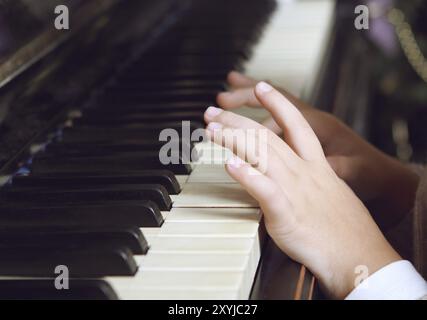 Close up de mains d'un enfant qui joue du piano Banque D'Images