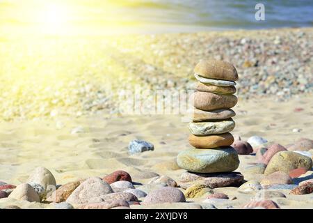 Pyramide de cailloux de couleur sur une plage ensoleillée Banque D'Images