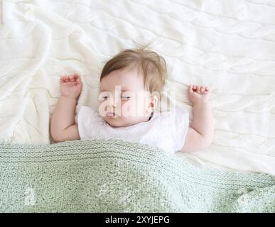 Gros plan sur un beau bébé endormi sur blanc Banque D'Images