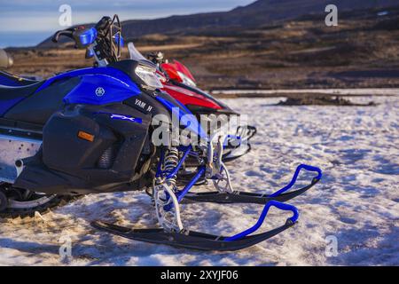 ISLANDE, 04 JUILLET : quatre motoneiges stationnées dans une rangée dans une épaisse neige hivernale en Islande dans un paysage hivernal froid désolant le 04 juillet 2013 à I. Banque D'Images