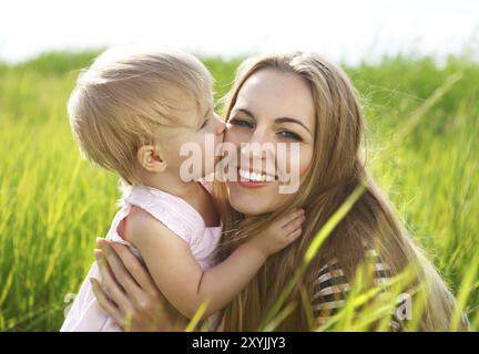 Heureuse mère et sa petite fille dans le champ d'été Banque D'Images