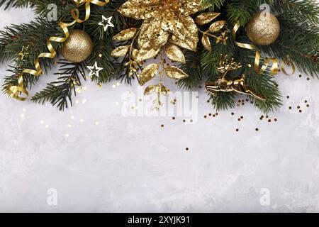 Fleur de Noël poinsettia décoration dorée sapin branche de pierre grise fond de copie espace plat pose Banque D'Images