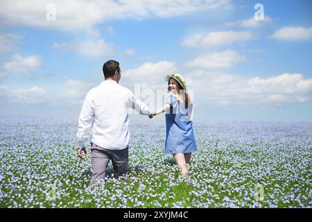 Portrait of a young happy pregnant couple dans champ de lin Banque D'Images