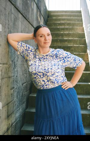 Portrain de mode de jolie femme de 40 - 45 ans posant à l'extérieur Banque D'Images