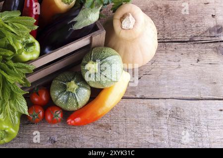 Des légumes frais dans des caisses en bois sur de vieux bois Banque D'Images