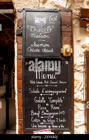 Menu manuscrit sur tableau noir affiché à l'extérieur du restaurant, St Guilhem le désert, Hérault, Occitanie, France, Europe Banque D'Images