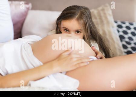 Jolie Jeune femme enceinte et sa petite fille. Concept de famille heureuse Banque D'Images