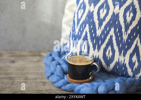 Oreiller bleu avec couverture et tasse de café sur le fond en bois. Close up Banque D'Images