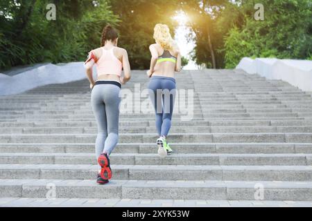 La formation à l'extérieur de coureurs dans le parc avec la lumière au coucher du soleil Banque D'Images