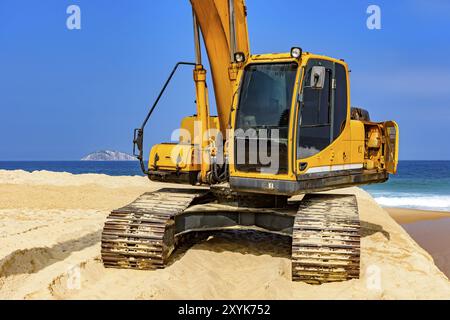 Cabine pelle jaune et le bras sur le sable à plage dans une journée ensoleillée Banque D'Images