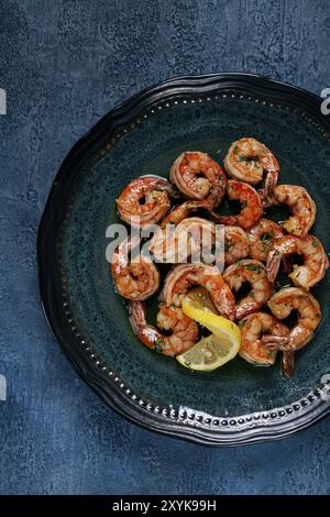 Crevettes tigrées frites, jumbo, dans la sauce à l'ail, dans le beurre, avec des herbes, sur une assiette, fait maison, pas de gens Banque D'Images