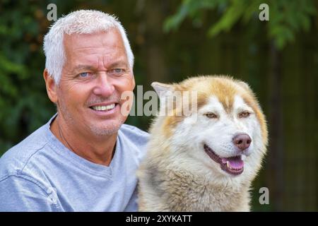 Portrait d'homme avec chien husky adultes Banque D'Images
