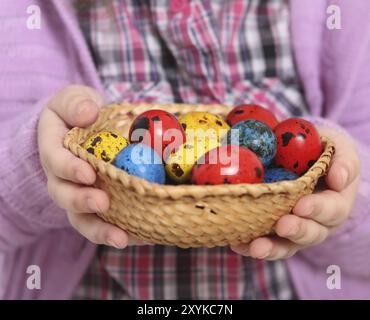 Mignonne petite fille tenant panier avec des oeufs de pâques. Gros plan Banque D'Images