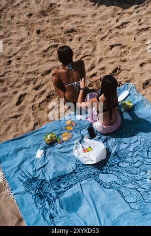 Une femme applique de la crème solaire à son amie. vue de dessus. Banque D'Images