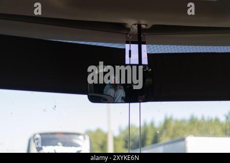 Femme voyageant en bus. réfléchi dans le rétroviseur. Banque D'Images