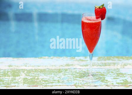 Verres de champagne à la fraise sur fond bleu turquoise. Cocktail Rossini. Summer pool party Banque D'Images