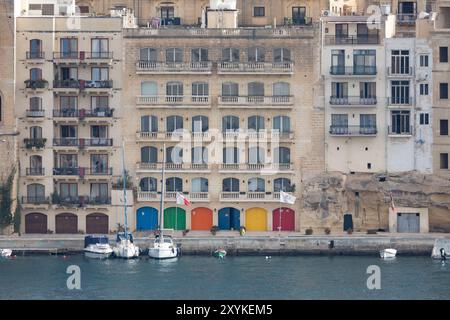 Vue sur le port de la Valette avec architecture pierreuse et portes colorées. Banque D'Images