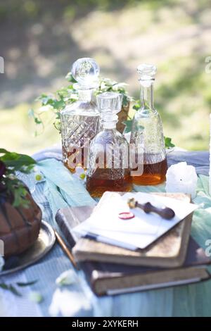 Cocolate gâteau décoré de fleurs et de trois carafes de whisky contre un arrière-plan gris clair avec copie espace Banque D'Images