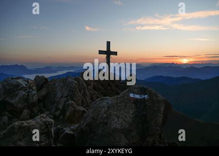 Mountain peak cross silhouette contre un lever de soleil à couper le souffle. Banque D'Images