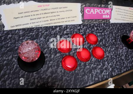 Leeds Angleterre : 2 juin 2024 : la configuration d'arcade classique de Capcom USA affiche un joystick et six boutons rouges vibrants, invitant les joueurs à s'engager dans la f classique Banque D'Images