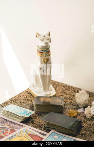 Ensemble d'un lecteur de tarot sur une table avec divers ponts de tarot, des cristaux, et un chat décoratif Banque D'Images