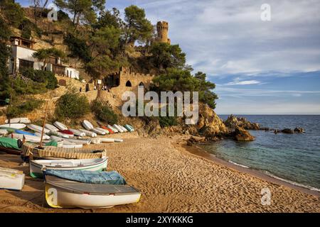 Lloret de Mar ville paysage pittoresque sur la Costa Brava en Catalogne, Espagne, plage avec des bateaux sur le sable et rocher avec un château à la côte de la Mer Méditerranée Banque D'Images