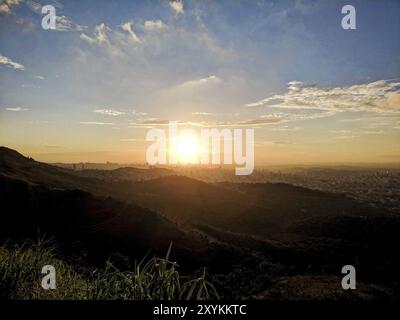 Vue depuis le haut de la ville de Belo Horizonte et ses collines, vallées, et des bâtiments pendant le coucher du soleil dans les montagnes du Curral Banque D'Images