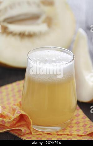 Melon de miel jus frais sur fond de bois Banque D'Images