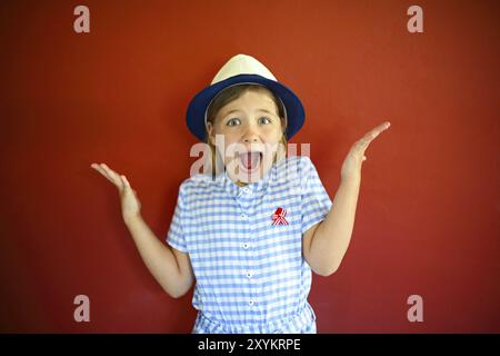 Très emothional les enfants portent un chapeau sur un fond rouge. Copie espace, lumière du jour Banque D'Images