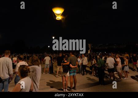Les spectateurs regardent le chaudron olympique s’élever au-dessus de la capitale française dans une montgolfière le mercredi 31 juillet 2024, à Paris, France. Banque D'Images
