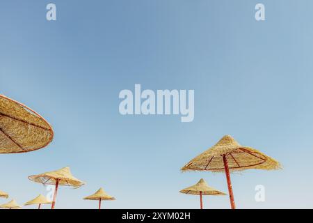 Vue sur un parasol en bois ou une cabane en chaume depuis le bas, avec une vue magnifique sur le ciel bleu ciel nuageux sur la plage tropicale de l'Égypte.Holida d'été ou d'hiver Banque D'Images