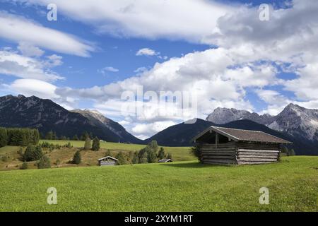 Quelques cabanes sur les prairies greem au-dessus du ciel bleu dans les Alpes bavaroises Banque D'Images