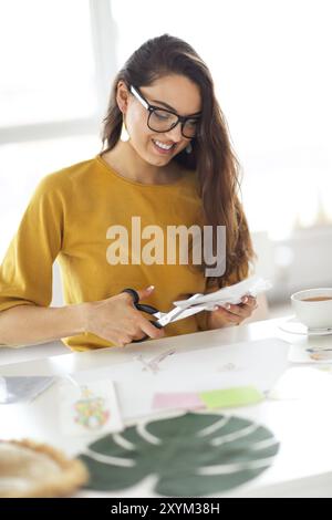 Jeune femme brune créer son souhait de Feng Shui site à l'aide de ciseaux Banque D'Images