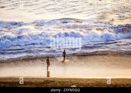 Un groupe de jeunes hommes s'amusant sur la plage Banque D'Images