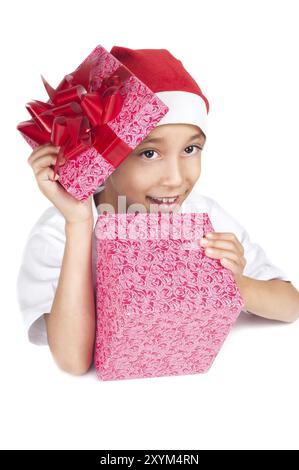 Garçon dans le chapeau rouge de noël tenant une boîte cadeau avec expression heureuse sur son visage avec copyspace blanc pour coller votre annonce ou bannière isolé sur BA blanc Banque D'Images